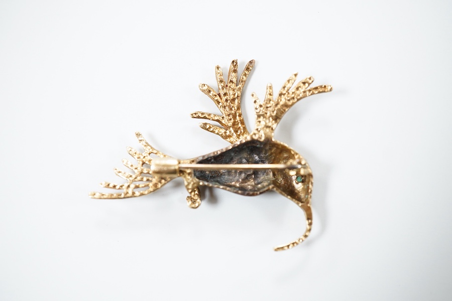 Two 9ct gold brooches, one designed as a collared leopard, its eyes set with rubies, length 5.2cm; the other designed as a hummingbird in flight, its eye set with an emerald, length 4.9cm, each in textured 9ct gold, Brit
